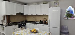 卡普里LA Giulia的厨房配有桌子和白色冰箱。