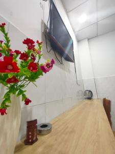 顺安Hotel Thanh Vân的花瓶,花朵红色,坐在桌子上