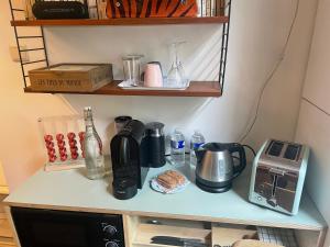 布鲁塞尔Petite Impasse privée的厨房柜台配有咖啡壶和电器