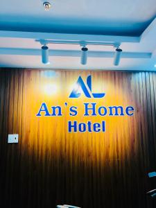 头顿An's Home Hotel Vũng Tàu的木墙上的一个标志,带有一间家庭旅馆