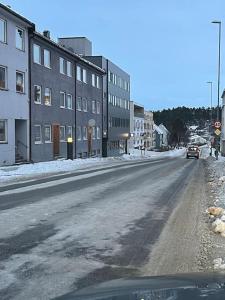 纳尔维克Narvik sentrum的一条空荡荡荡的街道,上面有建筑物和汽车