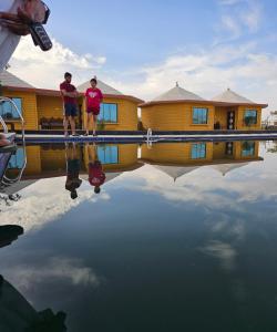 斋沙默尔Luxury The Sunrise Resort with swimming pool Jaisalmer的两个人站在水塘里