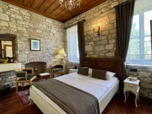伊兹密尔Urla Taş Konak Otel的一间卧室设有一张大床和石墙