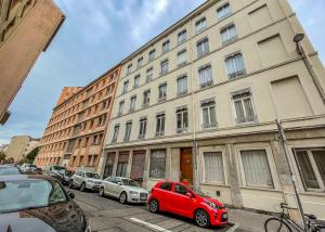里昂Apartment for 4 people with view of Fourvière AIL的停在大楼前的红色汽车