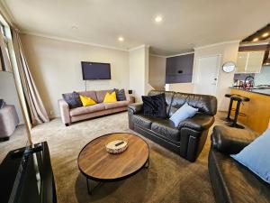 惠灵顿Executive, Spacious & Modern Home, 8 Beds!的客厅配有两张沙发和一张桌子