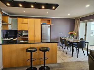 惠灵顿Executive, Spacious & Modern Home, 8 Beds!的厨房以及带桌椅的用餐室。