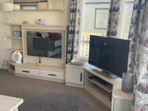 佩文西49 Bayside Cove Pevensey Bay Holiday Park的客厅配有大屏幕平面电视