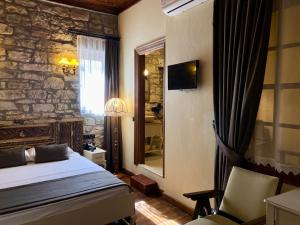 伊兹密尔Urla Taş Konak Otel的一间卧室设有一张床和石墙