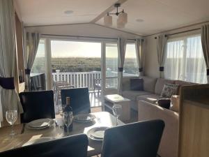 佩文西74 Bayside Cove Pevensey Bay Holiday Park的客厅配有沙发和桌椅
