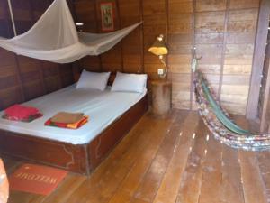 邦隆FamilyHouse & Trekking的一张位于带吊床的房间内的床铺