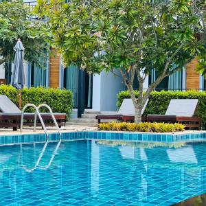 象岛常青象岛度假酒店的一个带两把椅子和一棵树的游泳池