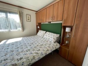 佩文西27 Tower View Pevensey Bay Holiday Park的一间卧室配有一张床和木制橱柜