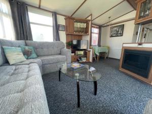 佩文西27 Tower View Pevensey Bay Holiday Park的带沙发和壁炉的客厅