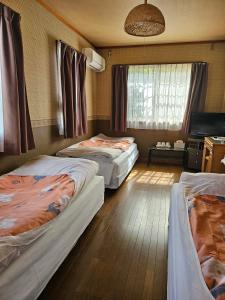 Shimo-taga枇杷物語的一间卧室设有两张床和窗户。