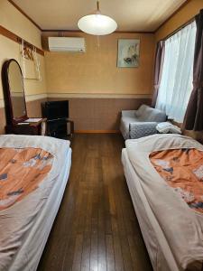 Shimo-taga枇杷物語的一间客房配有两张床和一张沙发