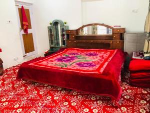 古尔马尔格Habib Guest House (Gulmarg)的一间卧室配有一张带红色毯子的大床