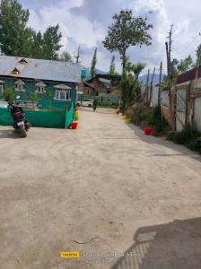 古尔马尔格Habib Guest House (Gulmarg)的停在大楼前的一条土路,一辆摩托车