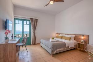 基萨莫斯Kaliviani Traditional Hotel的一间卧室配有一张床、一张书桌和一个窗户。