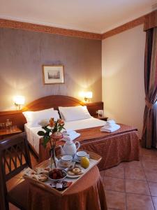 格罗塔费拉塔斯夸尔西亚雷里酒店的酒店客房设有两张床和一盘食物