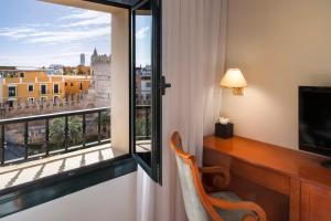 塞维利亚艾克斯塞维利亚玛卡瑞纳酒店的客房设有书桌和美景窗户。