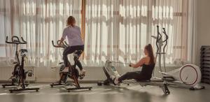 OzVillages Clubs du Soleil - OZ EN OISANS的两名女性在健身房使用健身自行车