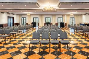 塞维利亚艾克斯塞维利亚玛卡瑞纳酒店的一间会议室,里面设有椅子和舞台