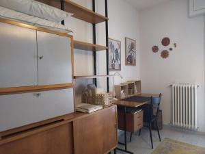 松德里奥La Casina Sondrio Valtellina的客房设有书桌和大型木制橱柜。