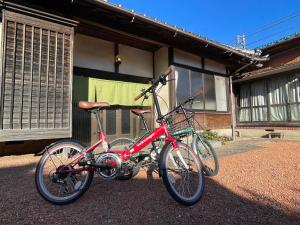 Nishiwada農家古民家ねこざえもん奥屋敷 Nekozaemon-Gest house的停在大楼前的一辆红色自行车