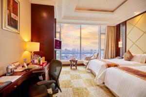 广州广州阳光酒店的酒店客房设有两张床和大窗户。