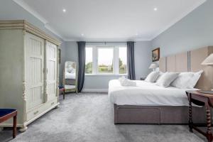 圣安德鲁斯Monksholm House - Sleeps 10 - 5 Mins from St Andrews的卧室设有一张白色大床和一扇窗户。