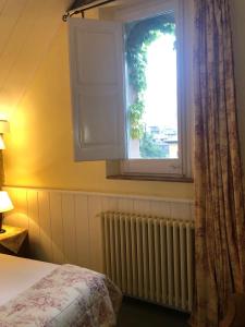 比拉德劳夏勒特克罗米娜酒店的一间卧室设有床、窗户和散热器