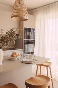 罗克布吕讷-卡普马丹Soleil Riviera Apartament Côte d’Azur的厨房配有带2张凳子的台面和微波炉