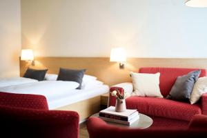 沃瑟姆阿尔伯格Hotel Steffisalp的酒店客房,配有两张床和两把椅子
