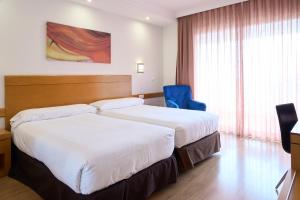 阿利坎特玛雅酒店的酒店客房,设有两张床和一张蓝色椅子