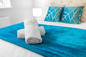 Stourbridge 2 Bedroom Apartment - Netflix & WIFI - Parking - 1CS的床上的一条毛巾,上面有蓝色地毯