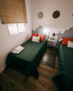El TornoCasa Rural VUT El Rincón de Eulogio的一间卧室设有两张绿色的床和一张桌子
