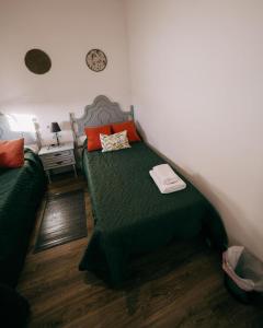 El TornoCasa Rural VUT El Rincón de Eulogio的一间卧室配有带绿床单和橙色枕头的床