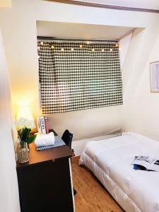 首尔NineRoD - Private bathroom & Shower的一间卧室配有一张床、一张书桌和一个窗户。