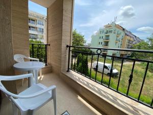阳光海滩Apartments Amara Sunny Beach的阳台配有桌椅,享有建筑的景致。