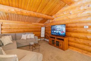 费尔班克斯Tucked Away Timbers的小屋内的客厅配有沙发和电视
