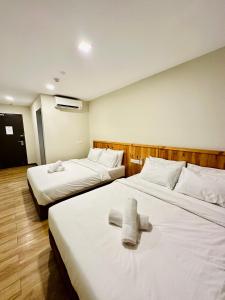 莎阿南Swing & Pillows - Apple Hotel Shah Alam的两张位于酒店客房的床,配有毛巾
