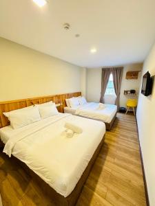 莎阿南Swing & Pillows - Apple Hotel Shah Alam的酒店客房设有两张床和窗户。
