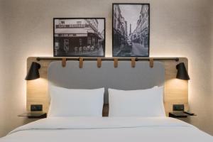 尼姆钟楼尼姆中央玛加博内尔酒店的一间卧室,床上方有两张图片