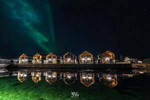 RisøyhamnRisøyhamn Sjøhus AS的夜空码头上的一排房子