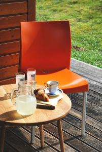 托波尔希卡Apartma Bazilika的坐在桌子旁的橙色椅子上,放着牛奶