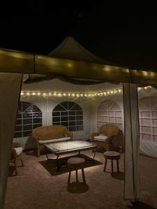 佩德罗－穆尼奥斯LA MANCHA SUITES CASA RURAL的帐篷配有桌椅和灯