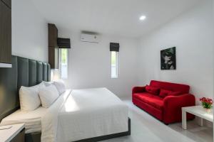 奥南海滩Lark Pool Villa Aonang Krabi的一间卧室配有一张床和一张红色的沙发