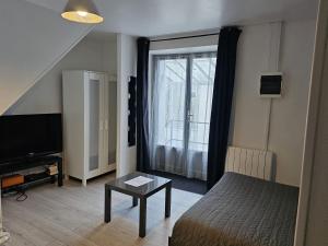 卢瓦尔河畔默恩Meung sur Loire sur la route des Châteaux的客房设有1张床、1台电视和1张桌子。