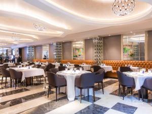 布宜诺斯艾利斯Palladio Hotel Buenos Aires - MGallery的一间设有白色桌椅的用餐室