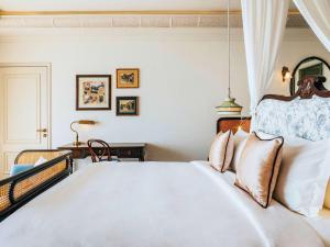 吉婆岛Hôtel Perle d'Orient Cat Ba - MGallery的卧室配有带枕头的大型白色床